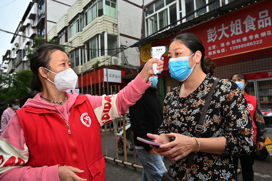 文化社区、志愿者正在为居民测量体温.jpg